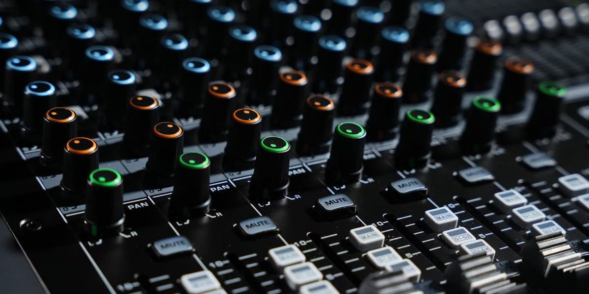 Detailed view of an audio mixing console with colorful lights in a professional studio setting.