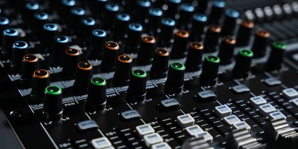 Detailed view of an audio mixing console with colorful lights in a professional studio setting.